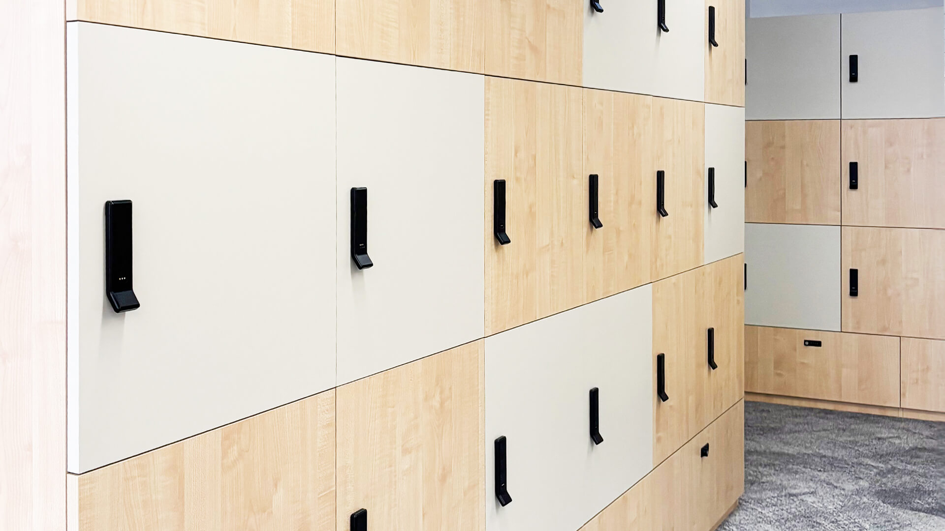 Modern wood and white locker cabinets with black handles line a clean hallway, creating a minimalist, organized atmosphere.